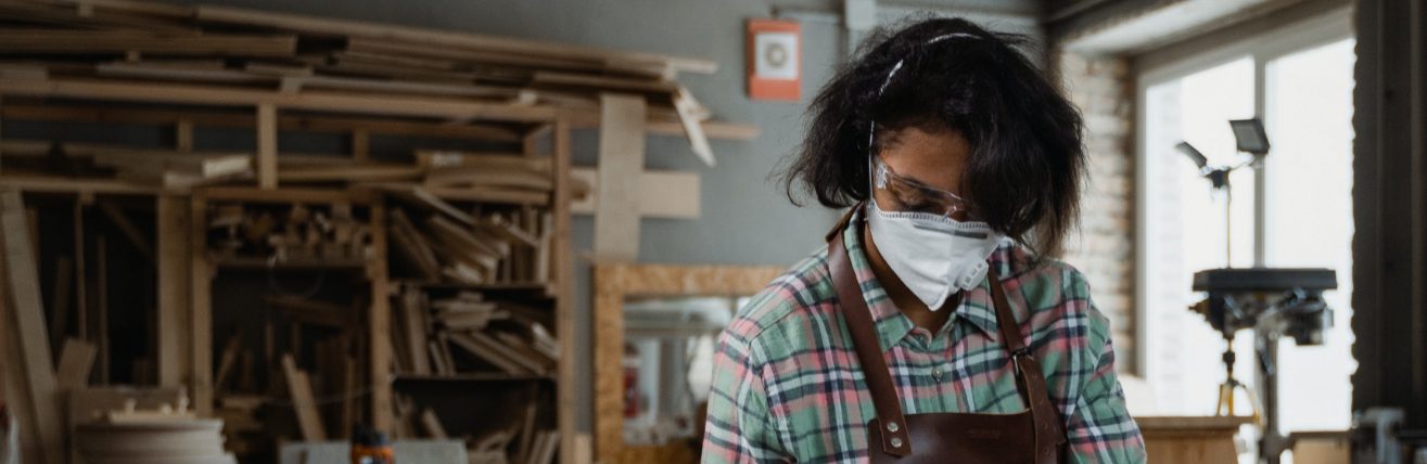 Woman with dust mask on looking down at the work she is doing